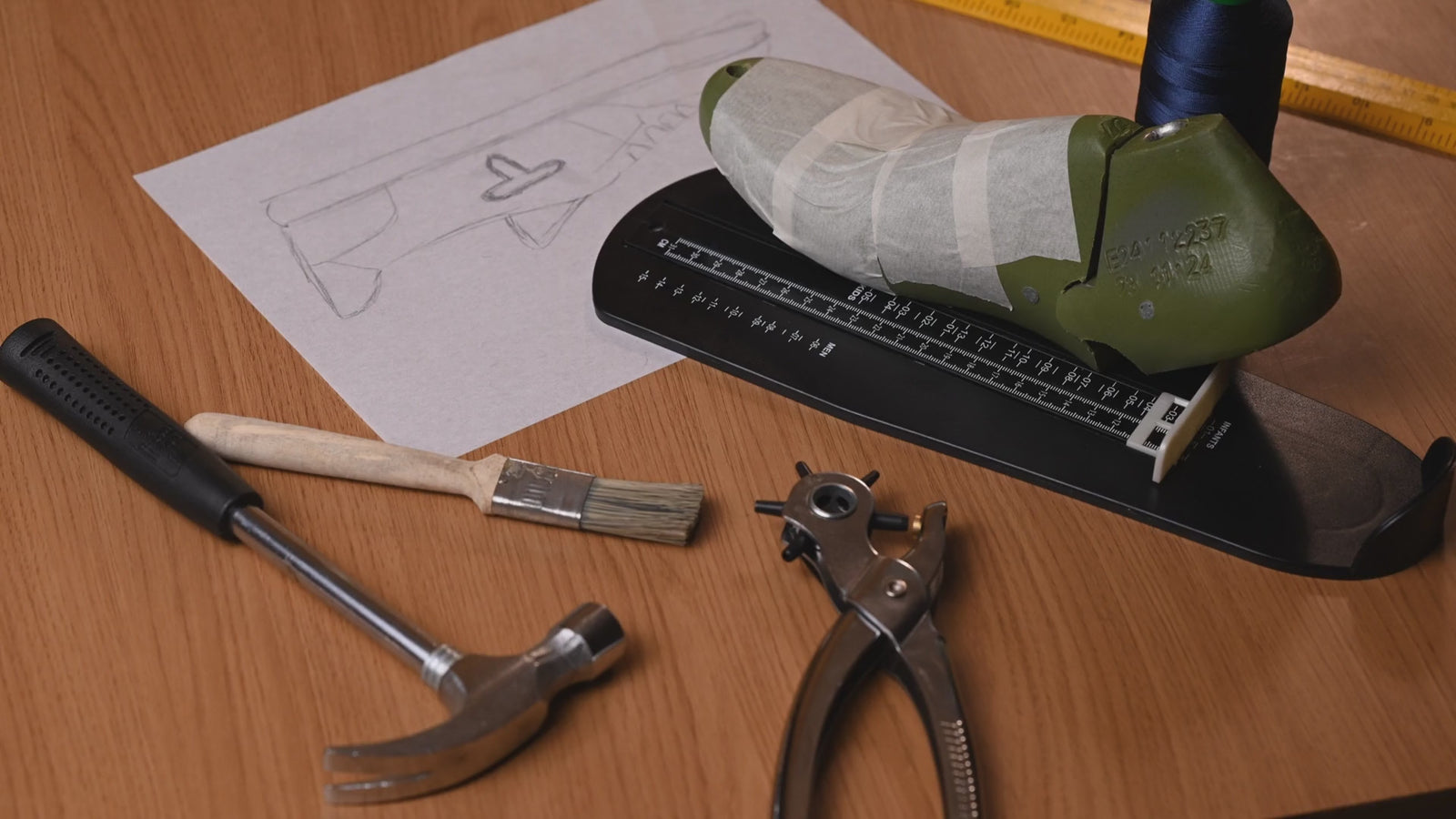 Shoemaking at Thylacin: the taped last and tools, inspection under a magnifier, stitching at the machine, the suede and metal emblem, the finished red sneaker