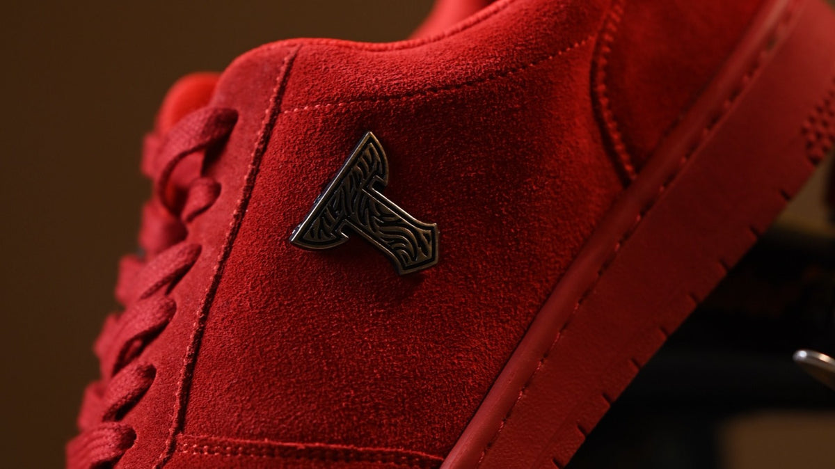 Close-up of red suede with the THYLACIN metal emblem