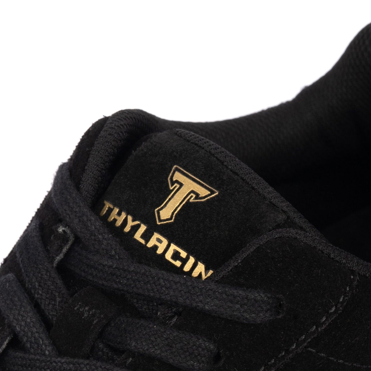 Thylacin Midnight Panther low-top sneaker in all-black suede — close-up of the suede and logo badge on the shoe