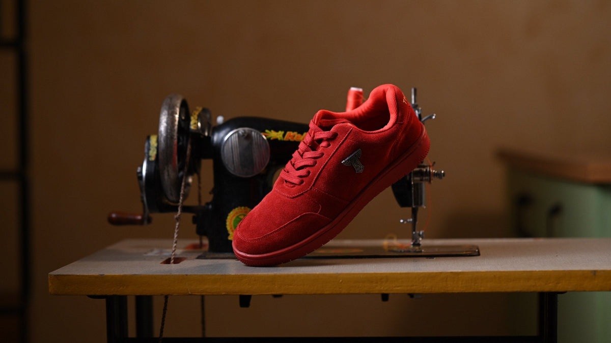 Red suede THYLACIN sneaker on a vintage sewing machine
