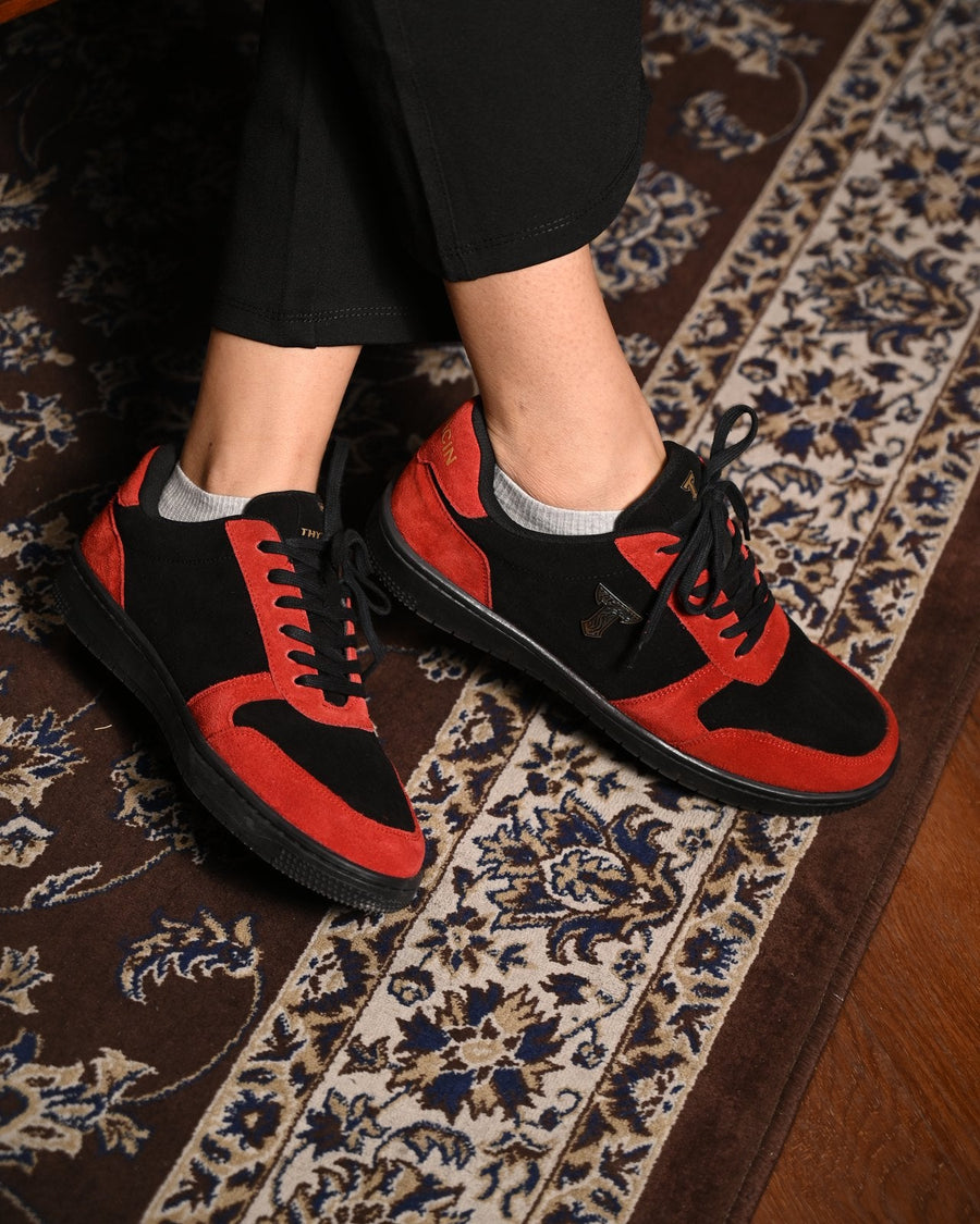 Ember Wolf red-and-black sneakers on a Persian rug